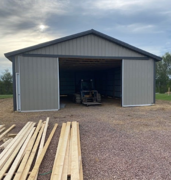 A garage built for agricultural equipment, a tractor sits inside